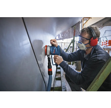 Un artisan utilise une ponceuse excentrique pour poncer une surface.