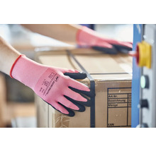 Un ouvrier manipule un carton et porte des gants de travail Gebol Master Flex Eco Lady.