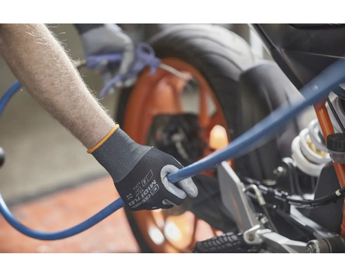 Eine Person hält einen blauen Schlauch mit einem Paar Arbeitshandschuhen in der Hand und reinigt ein Motorrad.