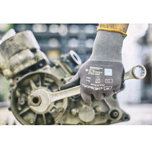 Main avec gant de travail et clé sur un moteur