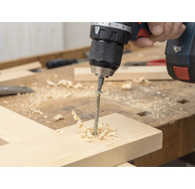 Tournevis sans fil vissé une vis dans une planche en bois