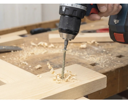 Tournevis sans fil vissé une vis dans une planche en bois