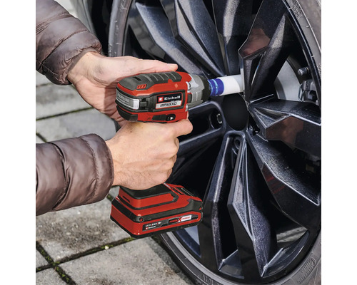 Clé à chocs sans fil changeant une roue sur une voiture