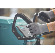 Une personne porte des gants de travail et utilise une machine.