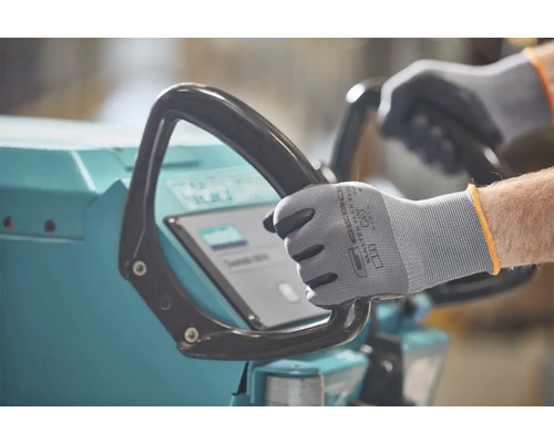 Une personne porte des gants de travail et utilise une machine.