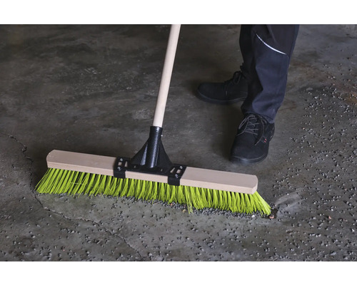 Balai avec manche en bois et poils colorés en utilisation