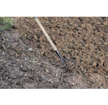 Dreizack-Gartenkralle mit Holzgriff im Gartenboden