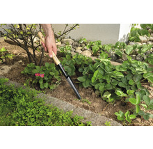 Scène de jardin avec un plantoir en utilisation pour planter des semis