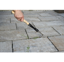 Nettoyeur de joints avec manche en bois utilisé sur des pavés.
