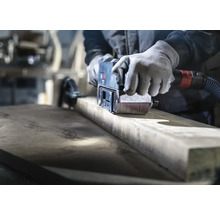 Artisan ponçant du bois avec une ponceuse à bande