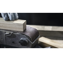 Gros plan d'une ponceuse à bande qui lisse une pièce de bois