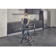 Frau arbeitet mit einer Werkbank und einer Schneidlade in einem Raum.