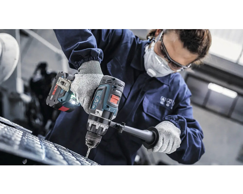 Une personne perce un matériau avec une perceuse sans fil.