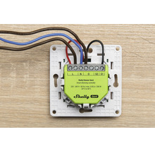 Contrôleur de variation intelligent Shelly Dimmer Gen4 dans un cadre de montage avec câbles électriques connectés pour pose encastrée.