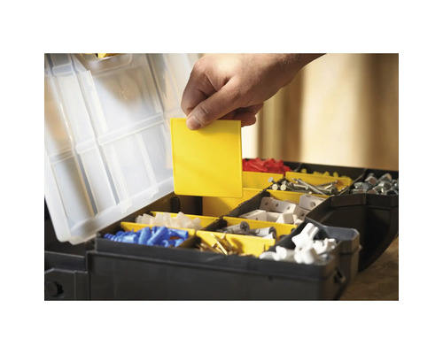 Offene Werkzeugkiste mit verschiedenen Fächern und einer Hand, die einen gelben Einsatz hält.