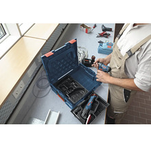 Artisan avec une boîte à outils et une visseuse sans fil