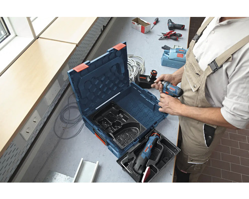 Artisan avec une boîte à outils et une visseuse sans fil