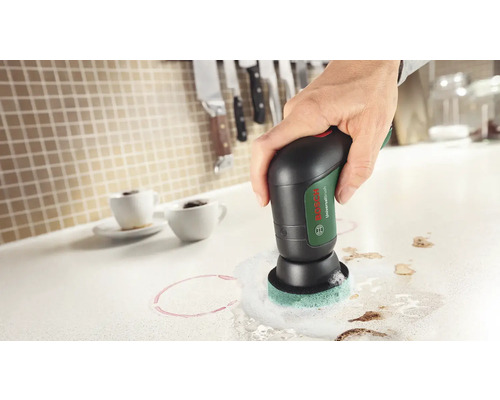 Brosse universelle Bosch en cours d'utilisation pour nettoyer un plan de travail de cuisine avec des taches de café
