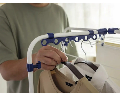 Une personne accroche des vêtements sur un étendoir.