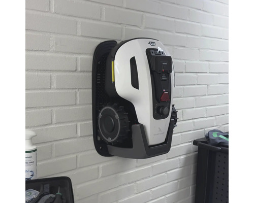 Robot tondeuse mural sur un mur de briques