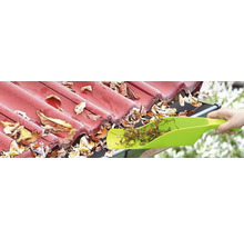 Nettoyage d'une gouttière avec une pelle pour enlever les feuilles