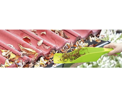 Nettoyage d'une gouttière avec une pelle pour enlever les feuilles