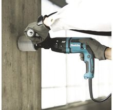 Marteau perforateur Makita avec aspiration de poussière utilisé pour percer un mur en béton.