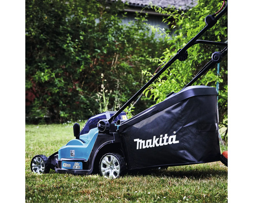 Tondeuse à gazon sans fil Makita, 36 Volt, largeur de coupe 430 millimètres, avec bac de ramassage et Makita Logo sur une pelouse dans un jardin.