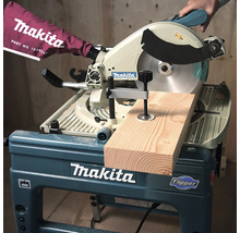 Scie à onglet et de table Makita Flipper coupant une planche de bois avec un serre-joint.