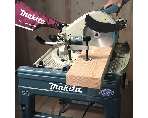 Scie à onglet et de table Makita Flipper coupant une planche de bois avec un serre-joint.