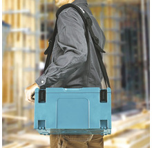 Une personne porte un coffret à outils Makita avec une bandoulière rembourrée sur un chantier lumineux. Makita Logo.
