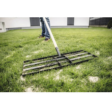 Rasenbaurakel auf Rasenfläche zur Bodenvorbereitung