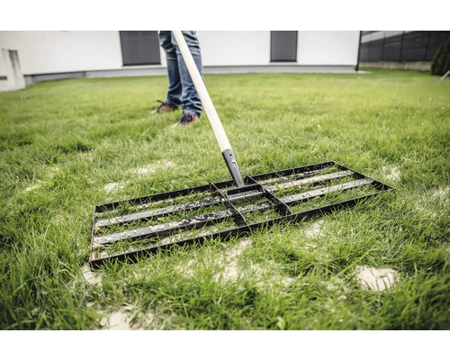 Rasenbaurakel auf Rasenfläche zur Bodenvorbereitung