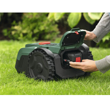 Tondeuse autoportée avec batterie insérée dans l'herbe