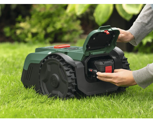 Tondeuse autoportée avec batterie insérée dans l'herbe