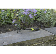 Gartenkralle mit drei Zinken und Kunststoffgriff vor Blumenbeet