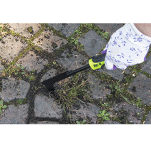 Une personne enlève les mauvaises herbes entre les pavés avec un désherbeur de joints for_q.