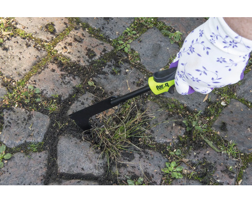 Une personne enlève les mauvaises herbes entre les pavés avec un désherbeur de joints for_q.