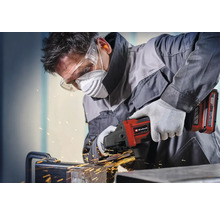 Handwerker arbeitet mit Einhell Akku-Winkelschleifer an Metall mit Funkenflug, trägt Schutzbrille, Atemschutzmaske, Gehörschutz und Handschuhe.