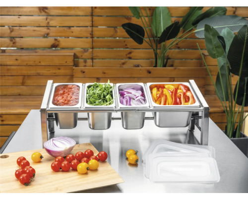 Zutatenstation aus Edelstahl mit vier Gastronorm-Behältern gefüllt mit Gemüse und Sauce auf einem Metalltisch mit Schneidebrett.