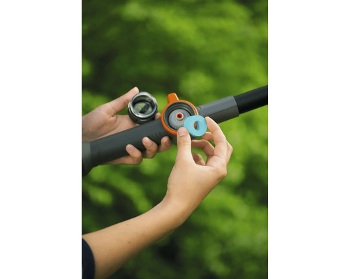 Insertion d'une pastille de nettoyage dans le compartiment d'une lance d'arrosage.