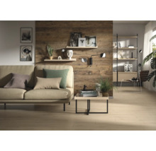 Salon moderne avec panneaux muraux aspect bois rustique, canapé beige avec coussins, table basse et étagères sur un mur en bois.