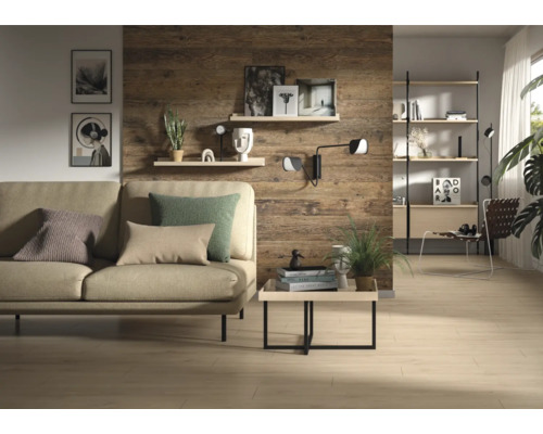 Salon moderne avec panneaux muraux aspect bois rustique, canapé beige avec coussins, table basse et étagères sur un mur en bois.