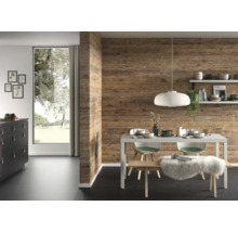 Salle à manger moderne avec revêtement mural aspect bois, table à manger blanche, suspension et grande fenêtre.