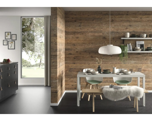 Salle à manger moderne avec revêtement mural aspect bois, table à manger blanche, suspension et grande fenêtre.