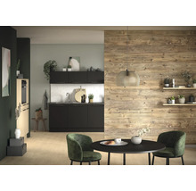 Cuisine moderne avec armoires noires, crédence en carreaux blancs et mur en bois. Devant se trouve une table ronde noire et des chaises vertes.