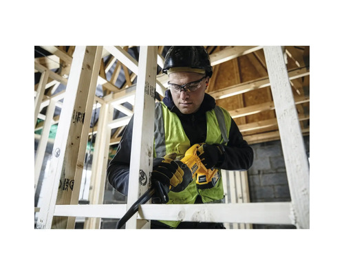 Artisan avec casque utilise une scie sabre sans fil DeWalt pour scier des poutres en bois dans une construction à ossature bois.