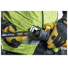 Une personne portant des gants de travail insère une lame de scie sabre DeWalt Extreme dans une scie sabre de 18 Volt.