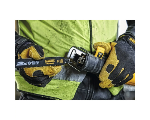 Une personne portant des gants de travail insère une lame de scie sabre DeWalt Extreme dans une scie sabre de 18 Volt.