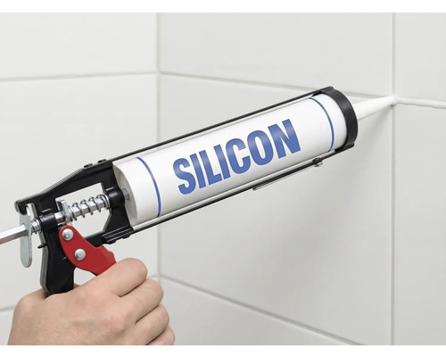 Application de silicone avec un pistolet à cartouche sur un joint de carrelage.
